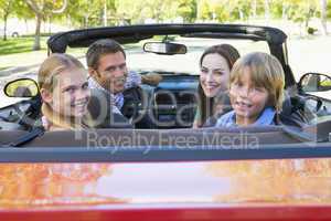 Family in convertible car smiling