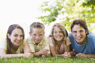 Family lying outdoors smiling