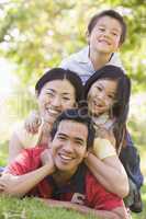 Family lying outdoors smiling