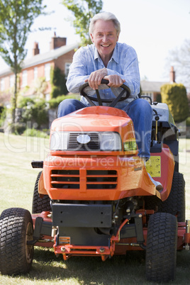 Man outdoors on lawnmower smiling