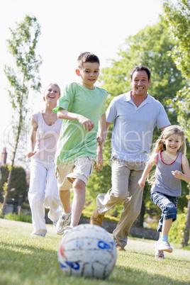 Family outdoors playing soccer and having fun