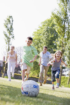 Family outdoors playing soccer and having fun