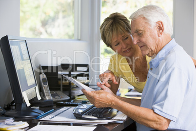 Couple in home office with computer and paperwork