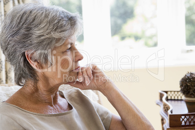 Woman in living room thinking