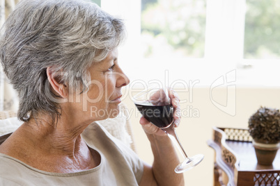 Woman in living room with glass of wine