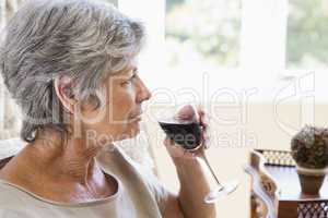 Woman in living room with glass of wine