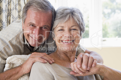 Couple relaxing in living room smiling