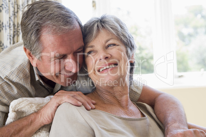 Couple relaxing in living room smiling