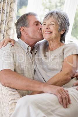 Couple relaxing in living room kissing and smiling