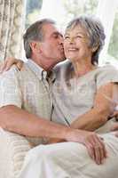 Couple relaxing in living room kissing and smiling