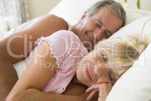 Couple lying in bed sleeping