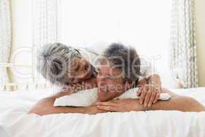 Couple relaxing in bedroom and smiling