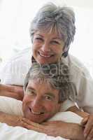 Couple relaxing in bedroom and smiling