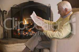 Man in living room reading newspaper