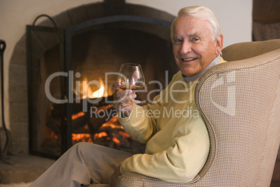 Man in living room with drink smiling