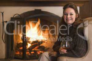 Woman in living room with drink smiling