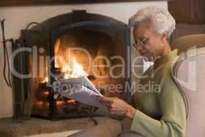 Woman in living room reading newspaper