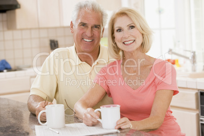 Couple in kitchen with coffee smiling