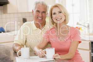 Couple in kitchen with coffee smiling