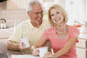 Couple in kitchen with coffee smiling