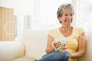 Woman relaxing in living room with coffee smiling