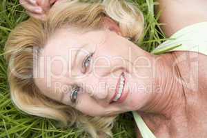 Woman lying in grass smiling