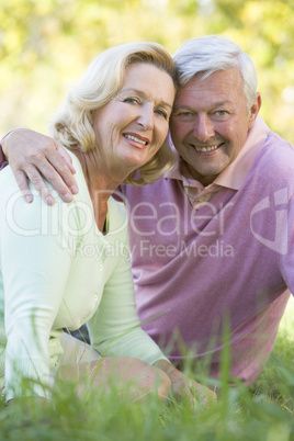 Couple relaxing in park smiling