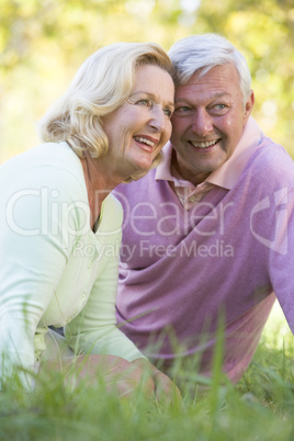 Couple relaxing in park smiling