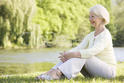 Woman outdoors at park by lake smiling