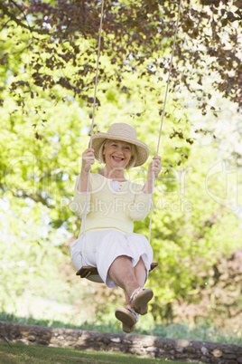 Woman on a swing outdoors smiling