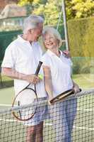 Couple playing tennis and smiling