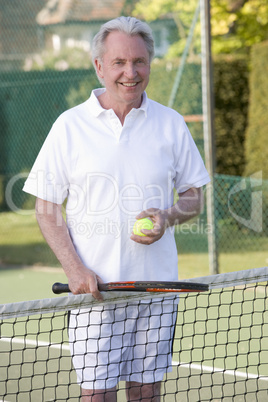 Man playing tennis and smiling