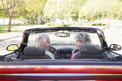 Couple in convertible car smiling