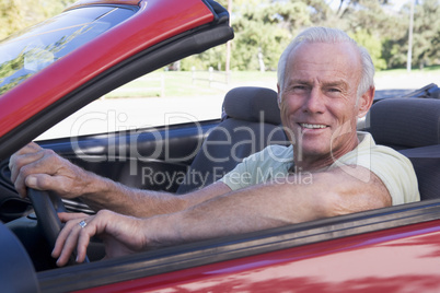 Man in convertible car smiling