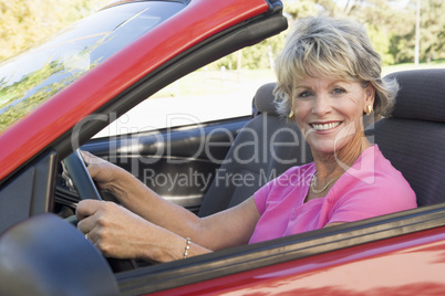 Woman in convertible car smiling