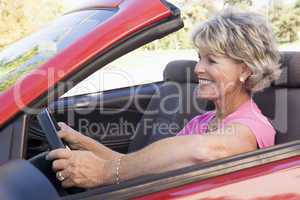 Woman in convertible car smiling