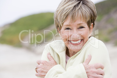 Woman at the beach cold and smiling