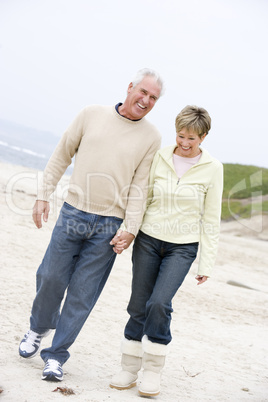 Couple at the beach holding hands and smiling