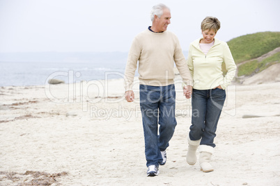 Couple at the beach holding hands and smiling