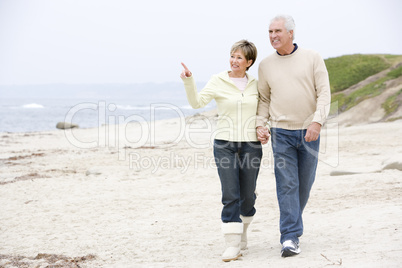 Couple at the beach holding hands and smiling