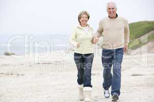 Couple at the beach holding hands and smiling