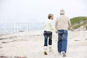 Couple at the beach holding hands and smiling