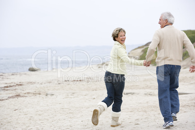 Couple at the beach holding hands and smiling