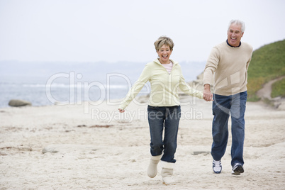 Couple at the beach holding hands and smiling