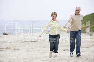 Couple at the beach holding hands and smiling