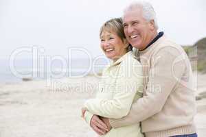 Couple at the beach embracing and smiling