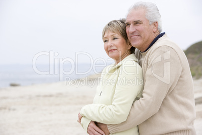 Couple at the beach embracing and smiling