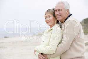 Couple at the beach embracing and smiling