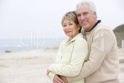 Couple at the beach embracing and smiling