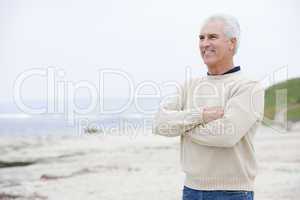 Man at the beach with arms crossed smiling